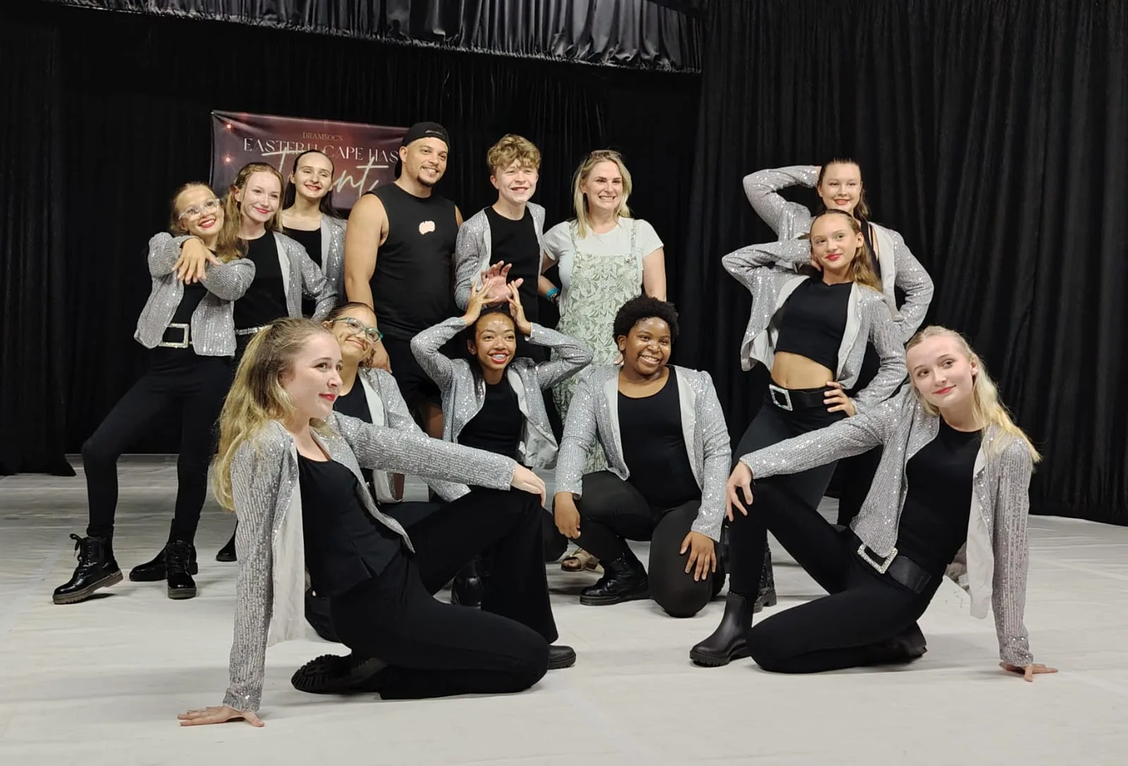 JJDC dancers in silver sequinned jackets posing together backstage at an Eastern Cape talent competition