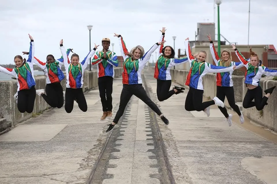 JJDC's national squad jumping for joy in matching South African tracksuits on a pier boardwalk