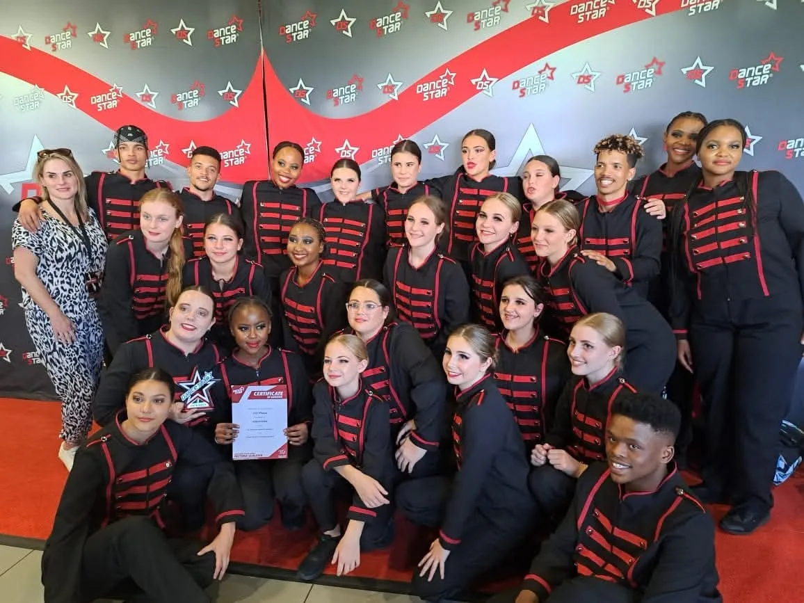 JJDC dancers in red and black military-style jackets holding a competition certificate at Dance Star South Africa